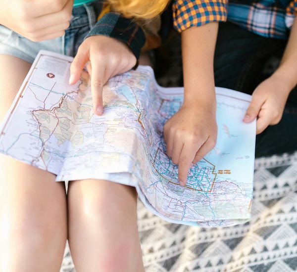 A compass pointing towards a handwritten word 'Joy' on a map.